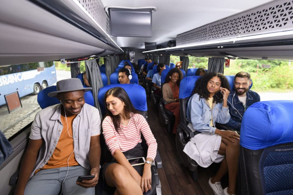 Pessoas felizes a viajar de ônibus (fonte: Google adaptada)