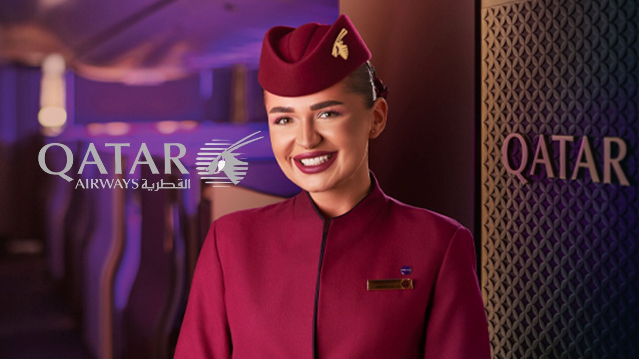 Aeromoça da Qatar sorrindo na entrada do avião