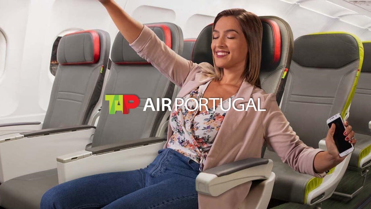 Mulher sorrindo, sentada e relaxada em assento de avião