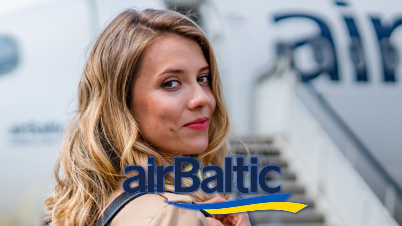Mulher olhando para câmera e sorrindo prestes a embarcar em aeronave da AirBaltic